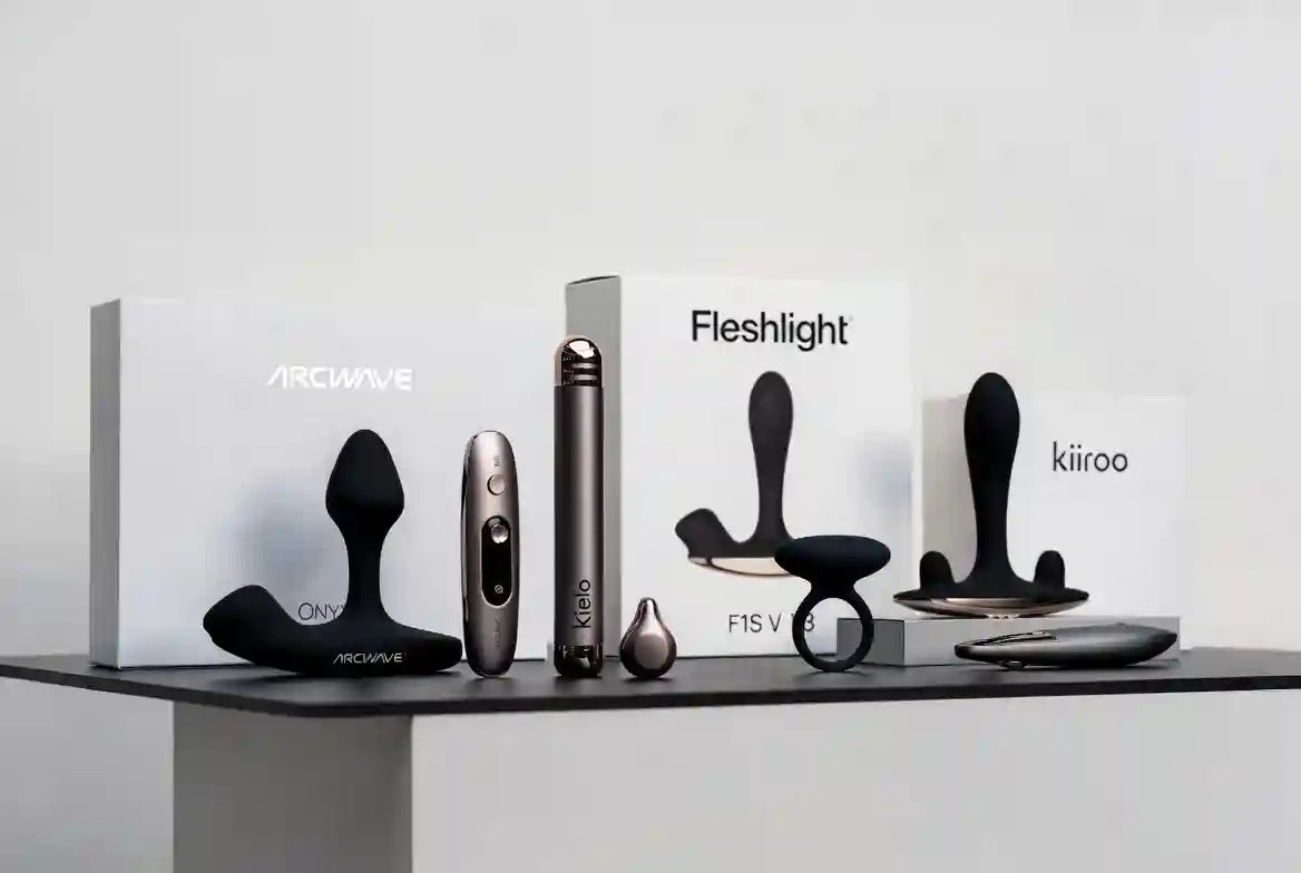 Sélection de masturbateurs premium et appareils male wellness exposés dans une galerie minimaliste - Kiiroo Onyx+, Arcwave Ion, Lelo F1S V3, design discret et luxury