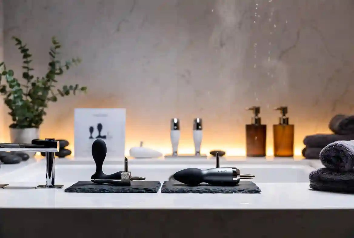 Appareil de massage prostatique premium Kiiroo sur surface de marbre blanc dans un environnement spa luxe - wellness masculine et santé prostatique
